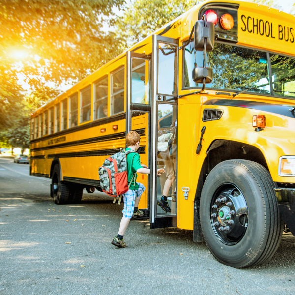 children getting on school bus